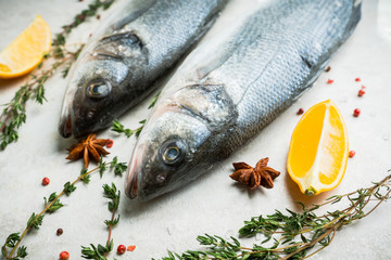 Raw whole seabass fish on the rustic background. Selective focus. Shallow depth of field.