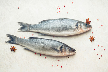 Raw whole seabass fish on the rustic background. Selective focus. Shallow depth of field.