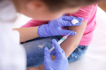 Obraz premium Little girl receiving chickenpox vaccination in clinic, closeup. Varicella virus prevention