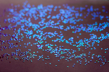 Purple or burgundy background. Iridescent sequins in the shape of a hexagon.