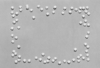 Confectionery topping is laid out in the form of a rectangle. Gray background. White snowflakes.