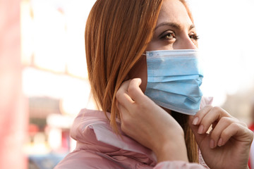 Woman with medical mask on city street. Virus protection