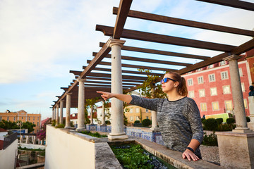 Beautiful women tourist looks at the red roofs of Lisbon from the viewpoint Miradouro de Santa Luzia