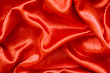 Folds of orange satin fabric.