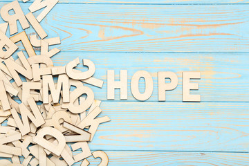 Word Hope by wooden letters on blue table