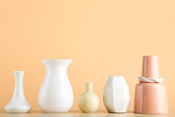 Different ceramic vases on beige background