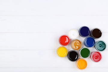 Colorful gouache paints on white wooden table