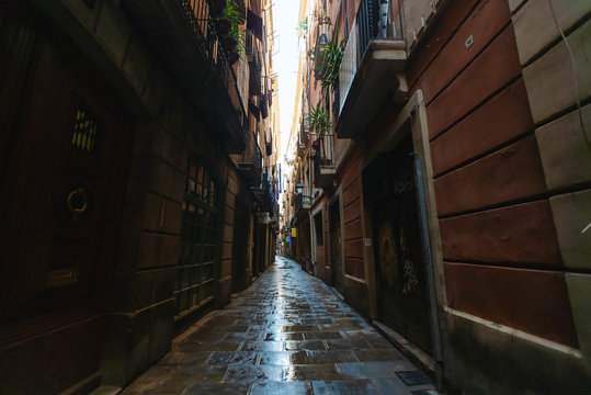View of narrow wet alleyway in Gothic quarter, Barcelona, Spain