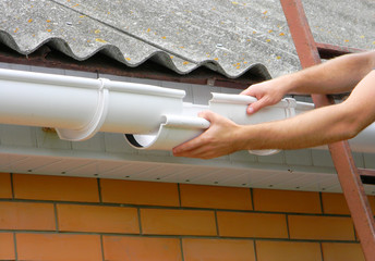 Rain gutter pipe renovation and repair on house asbestoc roof