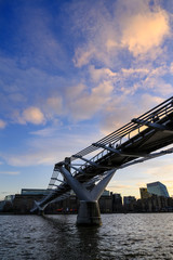 The Millennium Bridge in London, UK crosses the River Thames to the Tate Modern gallery with Blackfriars Bridge and the South Bank behind