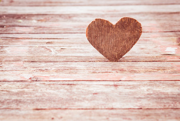 Vintage Valentine background. Shabby wooden heart on an old wooden table. Toned image. Copy space