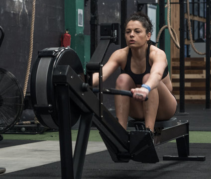 Woman training in the gym with the rowing machine