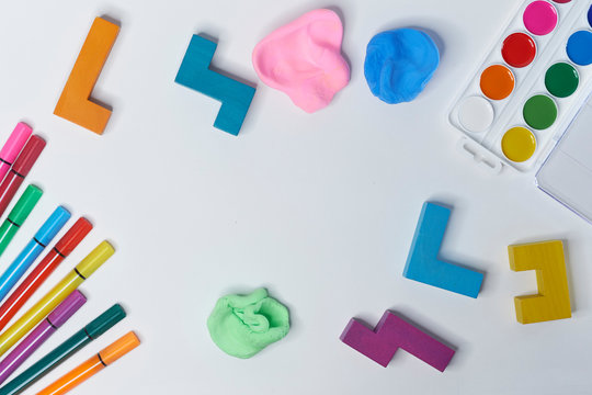 felt-tip pens, cubes, paints and plasticine on a white background. children's desktop. School, education and learning concept. creativity for kids. Top view colorful background. Flat lay