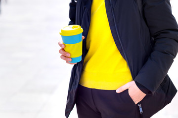 Female hands hold reusable coffee mug. Take your coffee to-go with reusable mug.