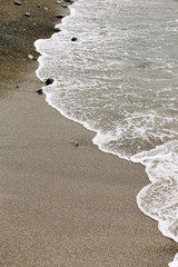 the sea wave arrives on the sandy shore . beautiful natural background