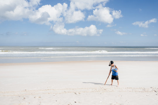 boy plays in sand on beach