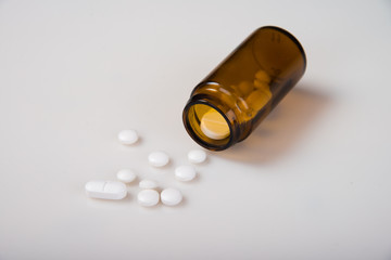 Pharmaceutical concept. Pills with a bottle on a light background.