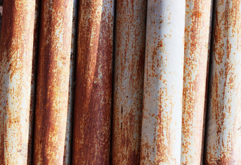 blue, rusty, metal pipes lie in one pile