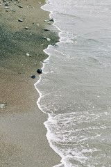 the sea wave arrives on the sandy shore . beautiful natural background