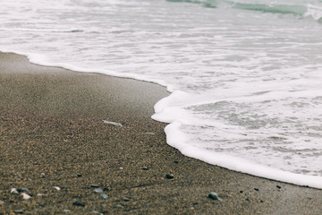 the sea wave arrives on the sandy shore . beautiful natural background