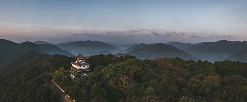 japanese castle on a mountain at sunrise