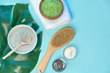 spa massage clay powder, face masks, bath salt, towel, shea butter on blue table background.