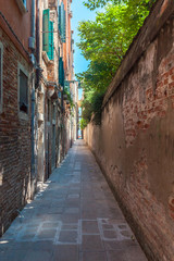 Fototapeta na wymiar Venice's narrowest street between brick walls, Italy