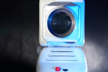 Old slide projector with slide frame photographed in the studio with flash light