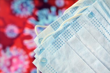 Sterile face protection mask with  inscription covid-19 against coronavirus, pollution, virus, flu on blurred background with corona virus bacteria. protection concept. breathing medical mask