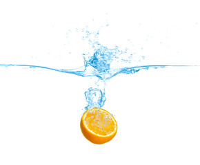 Ripe orange falling down into clear water with splashes against white background
