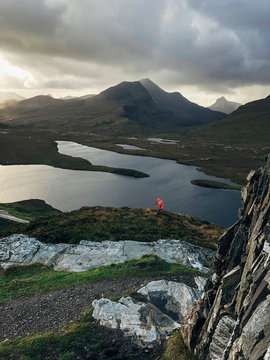 Walker and Storm clouds over Loch an Ais. Highlands, Scotland, UK.