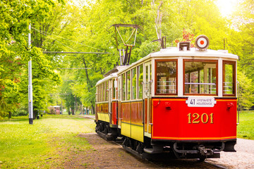 Retro tram on green street in sunny spring day in Prague, Czech republic