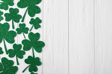 Flat lay composition with clover leaves on white wooden table, space for text. St. Patrick's Day...