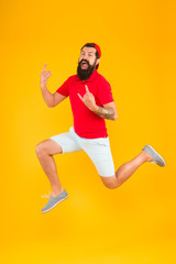 Fototapeta na wymiar Full of strength and energy. Hipster dancing jumping. Feeling free. Running man yellow background. feel himself energetic. time to relax. its summer vacation