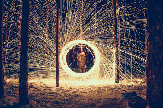 freezelight with steel wool against a gloomy winter forest