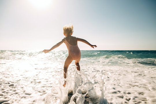Rear view of girl jumping in sea