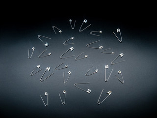 safety pins on a black background