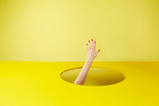 Hand appearing in yellow hole