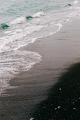 a sea wave arrives on the shore with black volcanic sand . beautiful natural background in Iceland