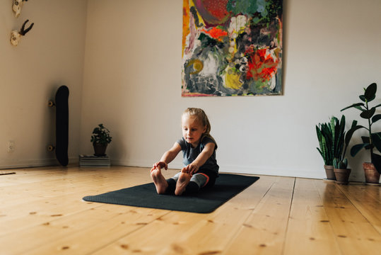 Little girl stretching on mat