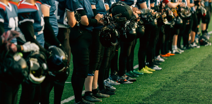 American football team with football helmets standing in football field