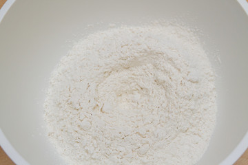 Cooking dough in a white plastic bowl at home