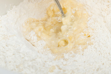 Cooking dough in a white plastic bowl at home