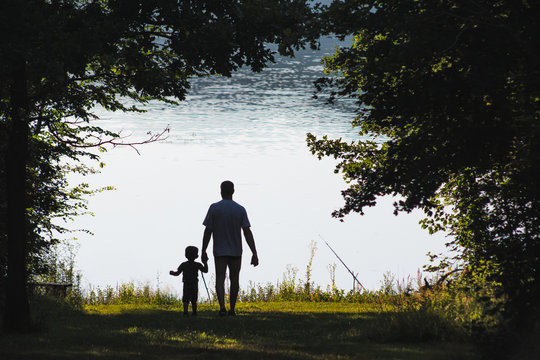 Anonymous father and child relaxing at the lake