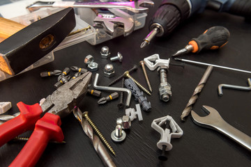 set of tools on the table, a screwdriver with a set of drill bits and screws with bolts. all for repair.