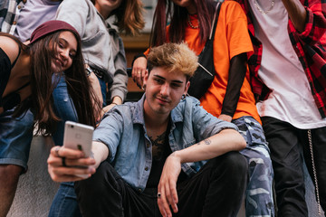 Portrait of cheerful young friends looking at smart phone.