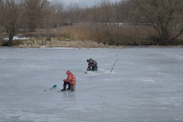 Fishermen fish in the winter on ice.