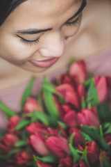 Woman smiling holding a bouquet of tulip flowers