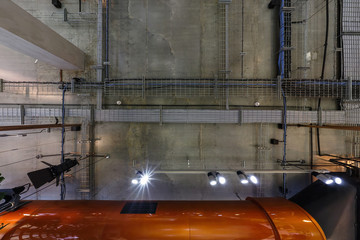 looking up on gray concrete ceiling with halogen spots and edison lamps in loft office room with...