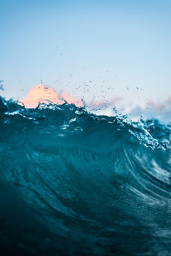 Maui Hawaii Glassy Crystal Clear Blue Wave Crashing on Seashore with Colorful Pastel Sunset Sky in Scenic Background in Tranquil Tropical Island Paradise Nature 